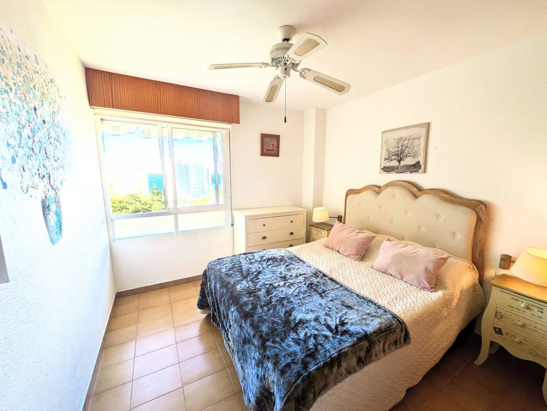 Dormitorio con cama doble, ventilador de techo y vistas al mar