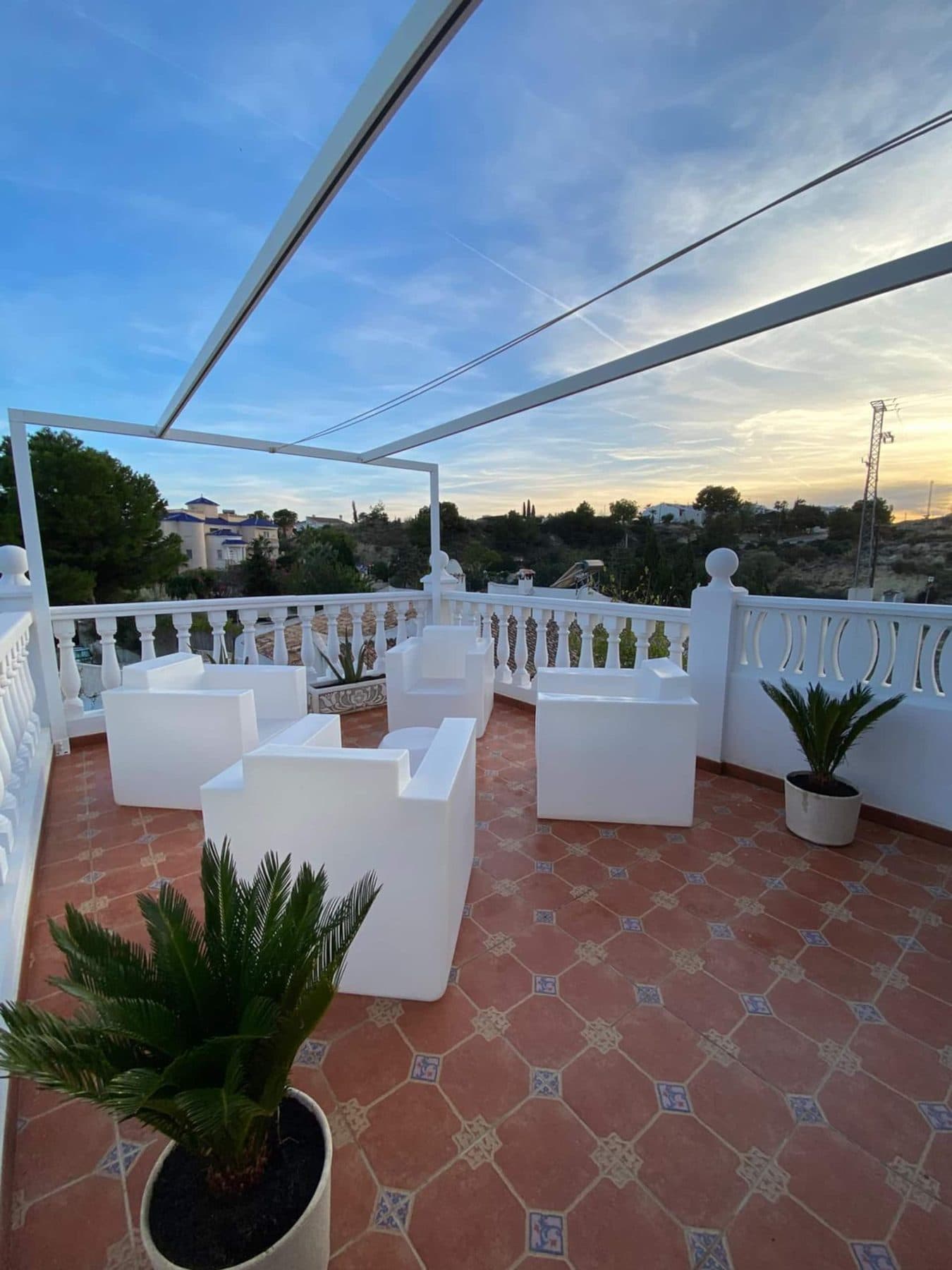 Terrasse blanche avec salon d’extérieur au coucher du soleil