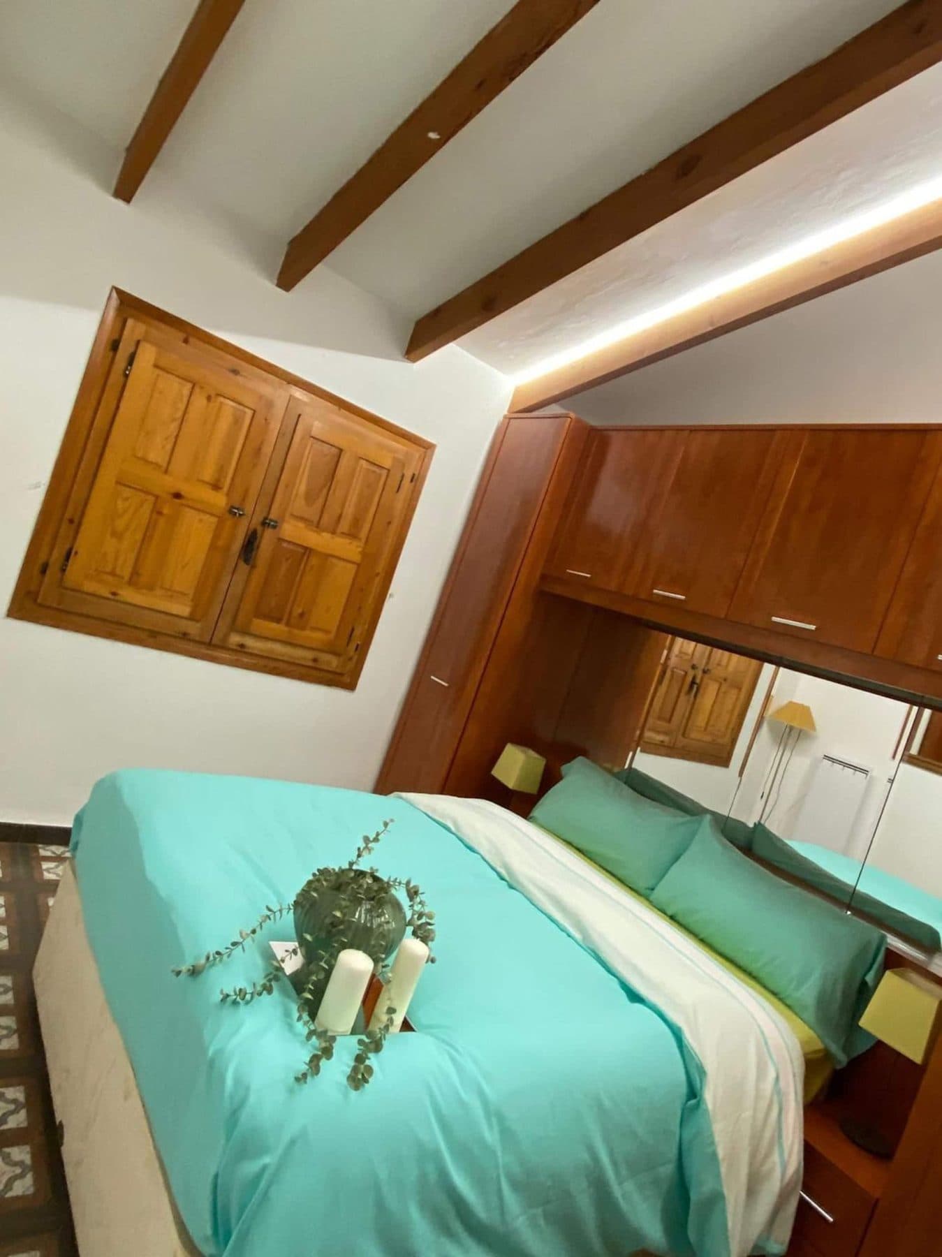 Bedroom with double bed and wooden wardrobe